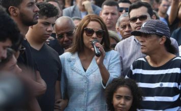 Filho de Flordelis aponta a mãe e três irmãs como suspeitas na morte do pai Deputada Flordelis discursa durante o enterro do marido, pastor Anderson, na última segunda-feira. Ao lado, de óculos escuros e camisa xadrez está Flávio, que admitiu à polícia participação no crime Foto: Fabiano Rocha / Agência O GLOBO