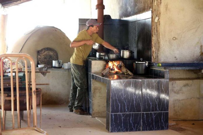 Homem fazendo comida com fogo a lenha | Fotos: José Cruz/Agência Brasil