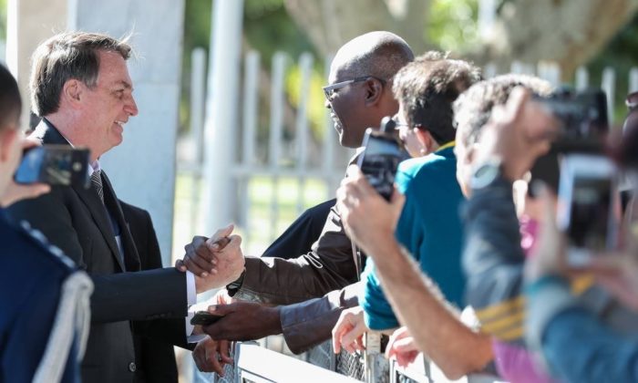 O presidente Jair Bolsonaro cumprimenta populares em frente ao Palácio da Alvorada Foto: Marcos Correa / PR