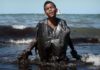 Foto de menino saindo do mar coberto por óleo roda o mundo como símbolo do desastre