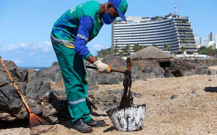 Agente de limpeza recolhe material na praia de Ondina, em Salvador, nesta quinta (Foto: Marina Silva/CORREIO)