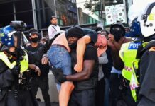 Homem negro carrega manifestante da extrema direita ferido e imagem viraliza